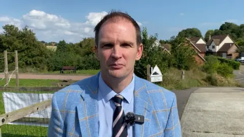 Dan Poulter in tie and blue jacket