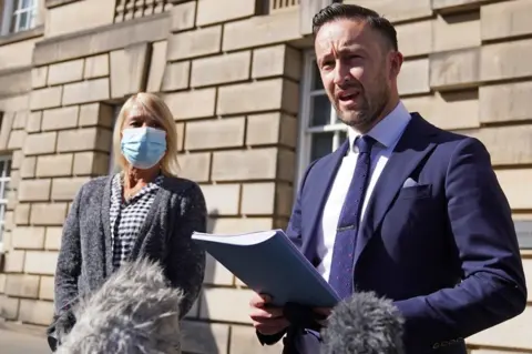 PA Media Solicitor David Nellaney makes a statement alongside Diane Bell