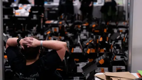 Getty Images A volunteer relaxes after processing ballot papers at the ExCel Centre on May 07, 2021 in London, England.