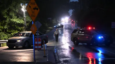 Getty Images Police monitor a wooded perimeter during the manhunt