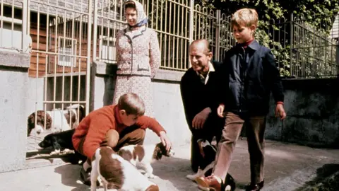 PA Media The Queen, Duke of Edinburgh and their two sons Prince Andrew (red sweater) and Prince Edward visit the kennels at Balmoral