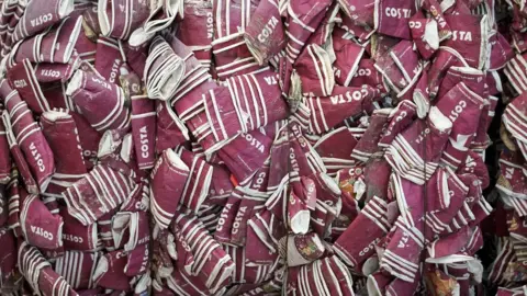 Getty Images These single-use coffee cups are being recycled at a plant in Cumbria to be turned into packaging