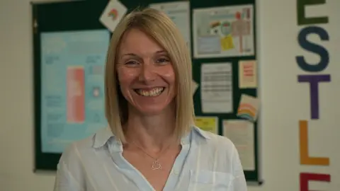 Jeff Thomas Tamasine Preece smiling while standing in a school classroom