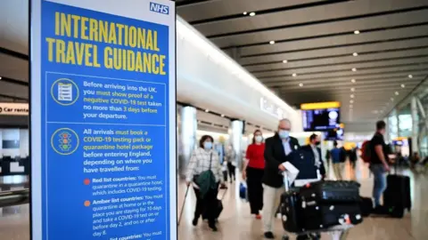 EPA Travellers pass a sign at Heathrow