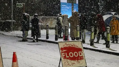 PA Media Snow falls in East Didsbury, Manchester, where homes are being evacuated due to risk of flooding