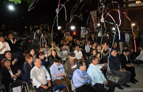 Getty Images Fans of Japanese novelist Haruki Murakami react when the Swedish Academy awarded the Nobel prize for literature to Japanese-born British novelist Kazuo Ishiguro at a shrine in Tokyo on 5 October 2017.