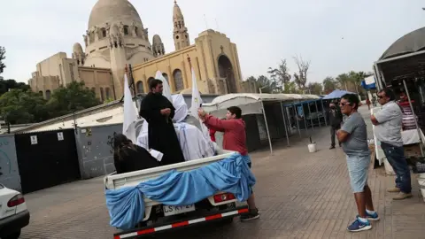 Reuters A priest uses a van to give blessings during Easter Saturday in Santiago, Chile
