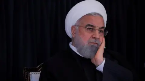 Reuters Rouhani with head in hands