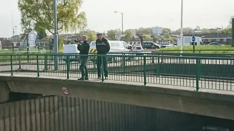 West Midlands Police  Officers on the bridge above the site