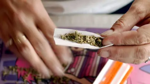 Getty Images Woman rolls a marijuana joint in San Francisco, California