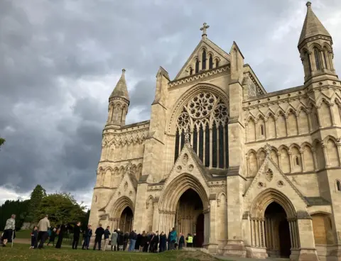 Katy Lewis/BBC Queues outside St Albans Cathedral for the service of commemoration and thanksgiving