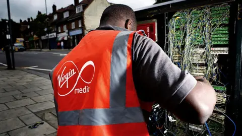 Newscast/Getty Images An engineer installing broadband
