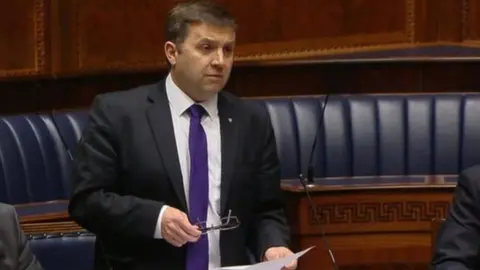 Robin Swann speaking in Stormont assembly chamber