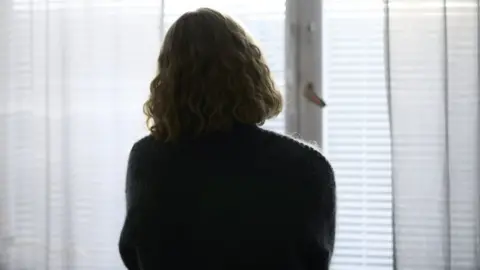 Getty Images A woman faces the window