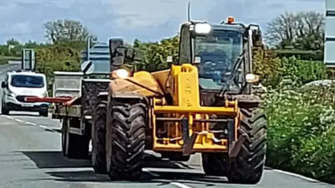 CPS the tractor with its overhanging load sticking out from the trailer