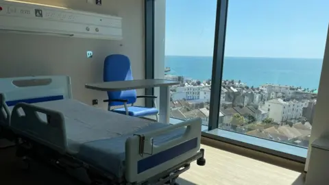 A ward showing one bed and a large sea-facing window