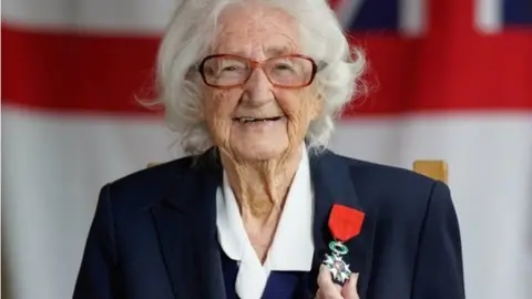 PA Media Lorna Cockayne smiling and wearing her medal