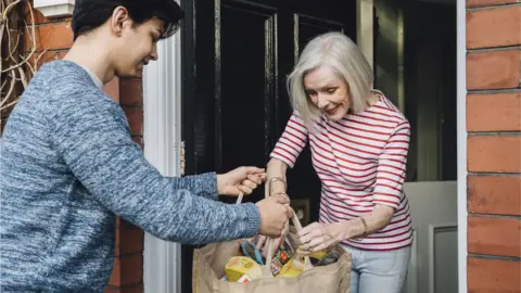 Getty Images Groceries dropped off at older woman's house