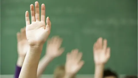 Getty Images hands up in a classroom