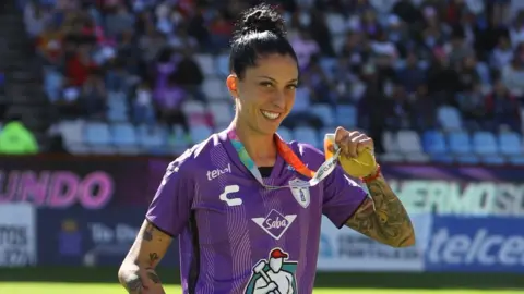 Reuters Spanish footballer Jenni Hermoso wearing a purple shirts and wearing her World Cup medal