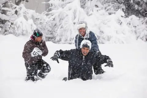 Pete Souza Obama plays in the snow with his children