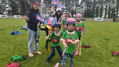 BBC Michael Davitt GAC and Cambodian team Cairde Khmer players pose for a picture holding camogie sticks