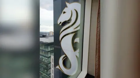 Seahorse logo on the side of the Grand Central Hotel in Belfast