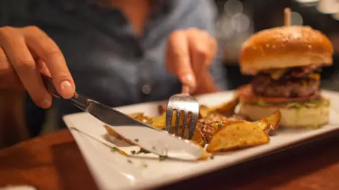 Getty Images Woman eating burger