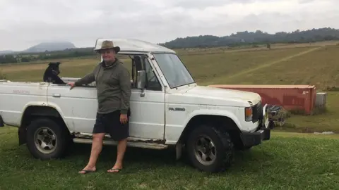 CRAIG CAULFIELD Craig Caulfield standing next to his ute on his old property