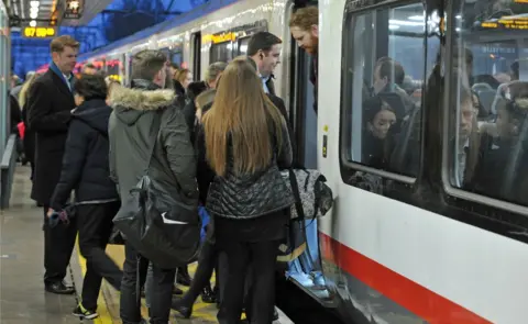 PA Media People getting on a train