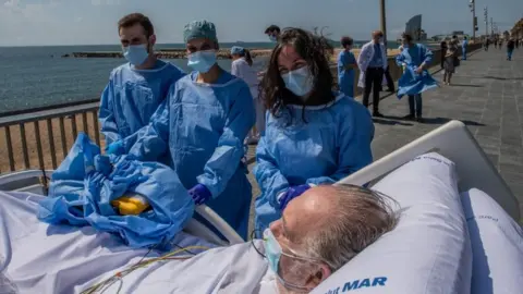 Getty Images Doctors in Barcelona take coronavirus patients to the beach