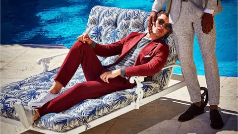 Suitsupply Image of Suitsupply advert showing two well-dressed men beside a pool