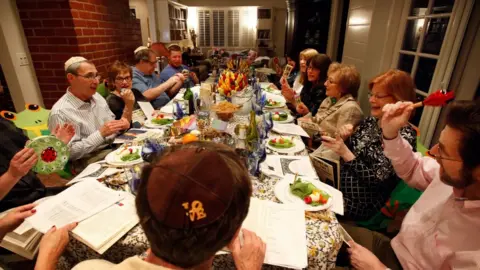 Getty Images A Jewish family celebrating Passover with the ritual Seder meal