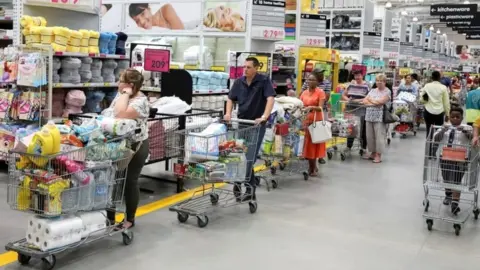 Reuters Shoppers stock up on groceries at a Makro store in Johannesburg, South Africa, 16 March 2020