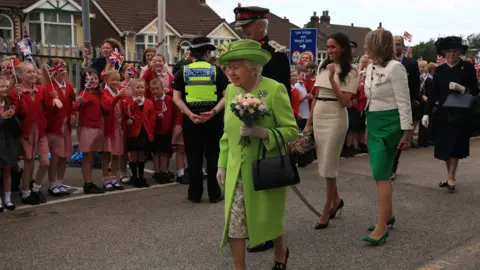 PA Queen and Meghan waving at crowds in Runcorn