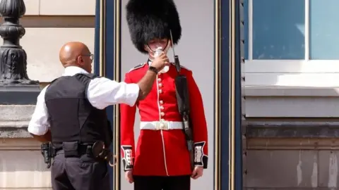 Reuters A Queen's Guard serviceman is given water