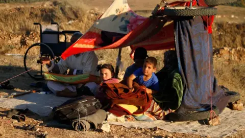 AFP Displaced Syrians from the Deraa province wait in a makeshift camp near the town of Nassib to cross the Jordanian border (1 July 2018)