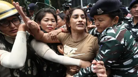 EPA Vinesh Phogat is detained by police during a protest in New Delhi in May