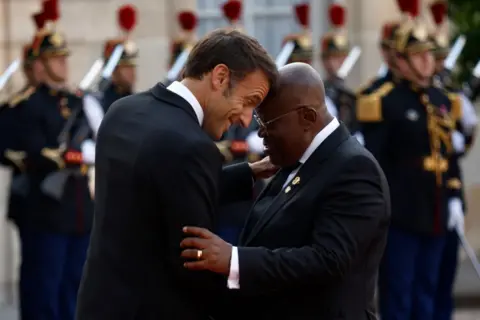 Yoan Valet / EPA-EFE French President Emmanuel Macron greets Ghanaian President Nana Akufo-Addo