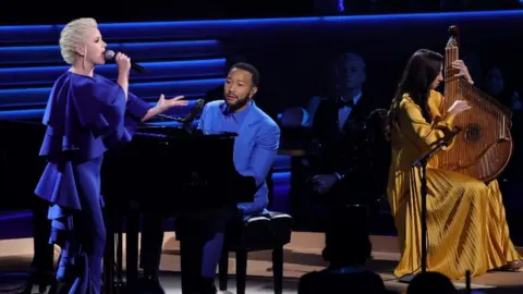 Getty Images (Left to right) Mika Newton, John Legend, and Siuzanna Iglidan performed onstage during the 64th Grammy Awards at the MGM Grand in Las Vegas on Sunday