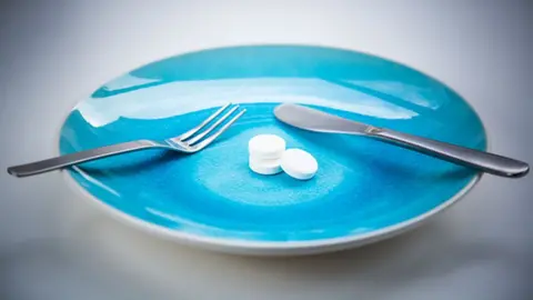 Science Photo Library A plate with cutlery and pills