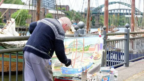 NNP Man painting tall ship scene