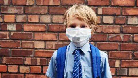 Getty Images Schoolboy wearing a face covering