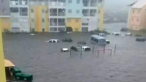 Handout/ RCI Guadeloupe Cars floating outside building