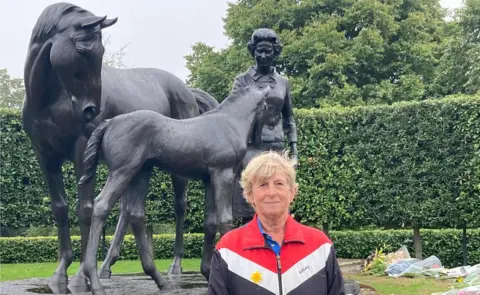 Rachael McMenemy/BBC Joanne Banks at the statue of the Queen in Newmarket