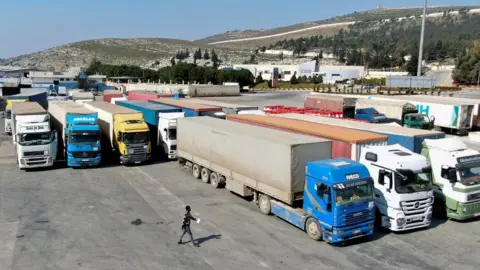 Reuters File photo showing lorries carrying UN aid at the Bab al-Hawa crossing, in Idlib province, Syria (20 February 2023)