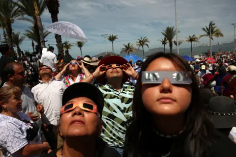 Henry Romero/Reuters People use special protective glasses to observe a total solar eclipse in Mazatlan, Mexico April 8, 2024.