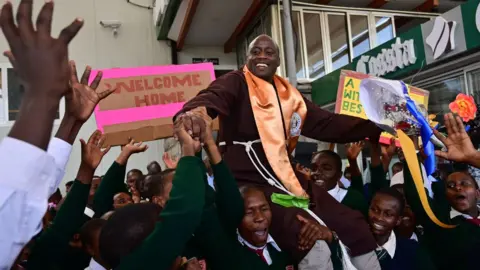 AFP Peter Mokaya Tabichi (top), is welcomed by his students on March 27, 2019 upon arrival at Nairobi's Jomo Kenyatta Airport from Dubai.