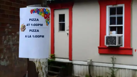 BBC A sign indicating a pizza day at the trailer park