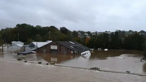 Daniel James Water submerging a garage and caravans